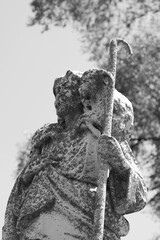 A statue of Jesus Christ holding a lamb in black and white.