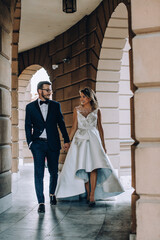 bride and groom walking in front of the library