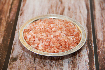 Small natural granules of Himalayan salt in a decorative plate