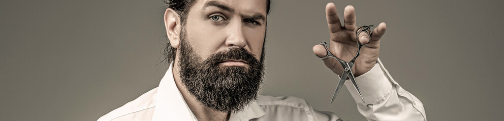 Male in barbershop, haircut, shaving. Bearded man isolated on gray background