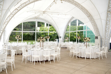 Tent for a wedding banquet. Large tent with tables and chairs. Wedding decorations.