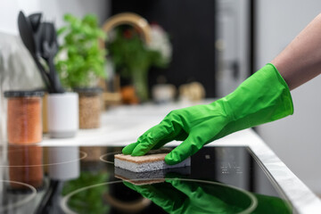 housewife wash glass ceramic hob indoors, closeup