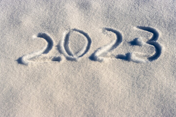 2023 written on fresh white snow during a sunny winter day