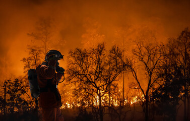Firefighters battle a wildfire because climate change and global warming is a driver of global...