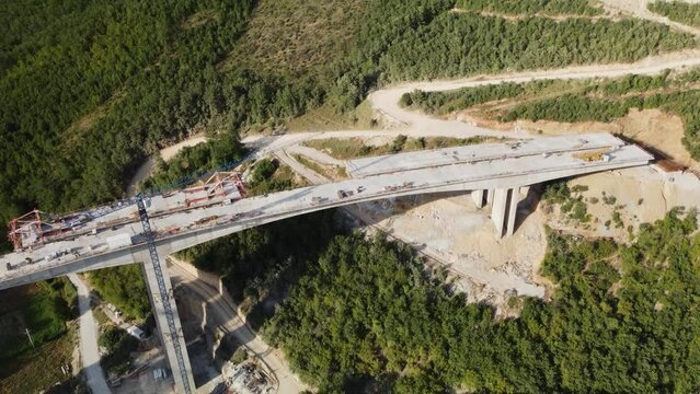 Highway bridge under construction. Aerial view of nes road. Freeway being built on a mountain terrain..