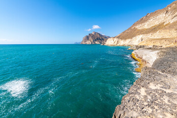 Fototapeta na wymiar The Dhofar Mountains and white sandy beach along the Arabian Sea at Salalah, Oman.