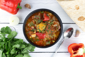 Khashlama - meat stew of beef or lamb meat with vegetables, lavash, spices on a gray background. Armenian and Georgian cuisine. 