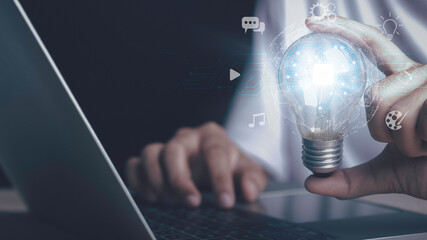 Artificial intelligence machine learning concept. Human hand hold digital brain of AI in light bulb be a help think creativity idea Music, Movie, Chat bot. Analytics big data around the world.