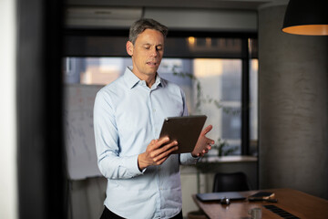 Fototapeta na wymiar Portrait of businessman in office. Man using digital tablet. Businessman having video call.
