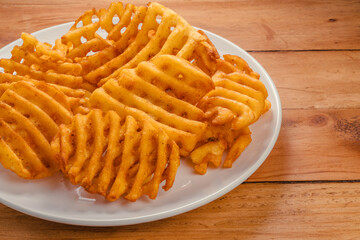 Fried Wafer Potato in white plate on wooden background, Fried wafer potato on wooden background.