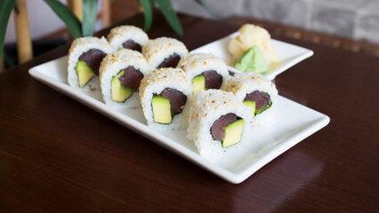 Tuna uramaki in Japanese restaurant. Combination of sushi roll with fish wrapped with rice.
