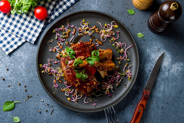 Barbecue pork ribs on black plate top view