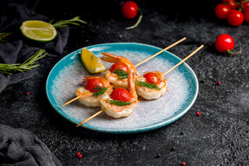 tiger shrimp kebab with mini tomatoes on blue plate
