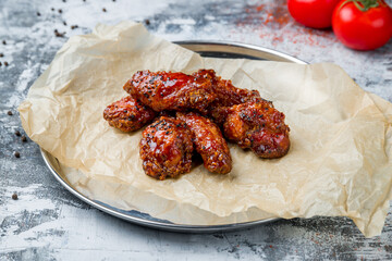 chicken wings in barbecue sauce on grey table