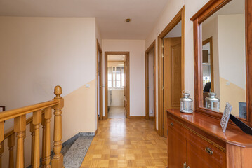 Distributor of a single-family house with several floors with a staircase with a wooden balustrade and access with wooden doors to different rooms