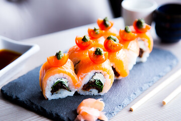 Uramaki with salmon. In the same way it is a rolled sushi, only that the external layer is sushi rice and the internal one is nori seaweed.