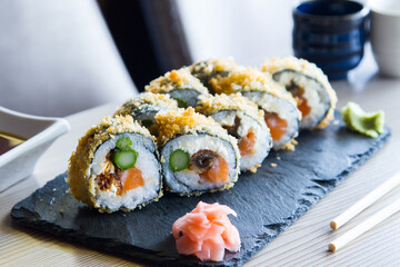 Uramaki with salmon. In the same way it is a rolled sushi, only that the external layer is sushi rice and the internal one is nori seaweed.