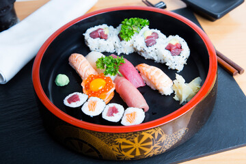 Set of sushi with variety of makis, nigiris and sashimi with fine fish like salmon and tuna.