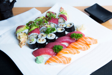 Set of sushi with variety of makis, nigiris and sashimi with fine fish like salmon and tuna.