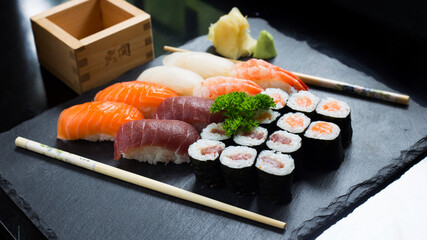 Set of sushi with variety of makis, nigiris and sashimi with fine fish like salmon and tuna.
