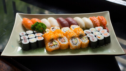 Set of sushi with variety of makis, nigiris and sashimi with fine fish like salmon and tuna.