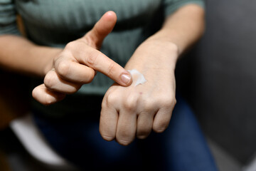 woman applying cream on her hands at home