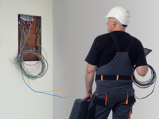 Inspector examines wiring. Man looks at place for electrical panel. Quality control electrical...