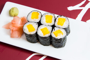 Vegan Maki sushi with rice and seaweed stuffed with vegetables and vegetarian ingredients.