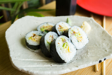 Vegan Maki sushi with rice and seaweed stuffed with vegetables and vegetarian ingredients.