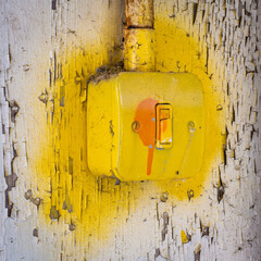 Light switch in abandoned building sprayed yellow