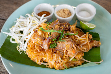 Pad Thai and Condiments on banana leaf and green plate