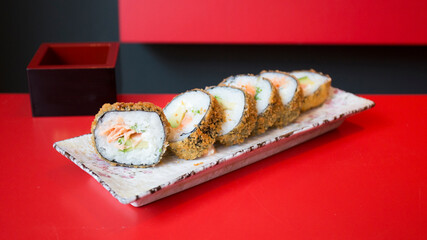 Salmon hot roll. Sushi roll stuffed with salmon and fried whole with breadcrumbs.