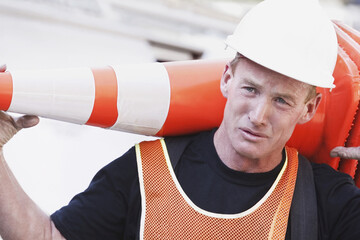 Repairman carrying a traffic cone