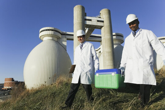 Two scientists carrying a container