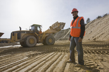 Engineer at a construction site with a front-end loader in the background