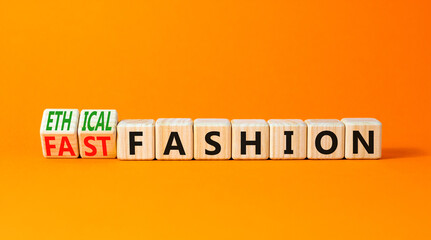 Fast or ethical fashion symbol. Concept words Fast fashion and Ethical fashion on wooden cubes. Beautiful orange table orange background. Business fast or ethical fashion concept. Copy space.