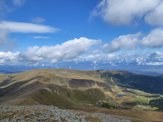 Panoramic aerial view of Lavanttal Alps, Koralpe and Wildsee seen from Zirbitzkogel, Seetal Alps, Styria, Austria, Europe. Landscape of hills, forest, lakes, alpine pastures on a cloudy moody day