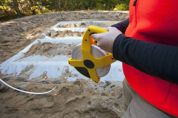 Female engineer measuring a leach field with a tape measure