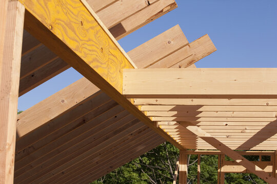 Low angle view of roof rafters with beams and joists