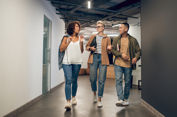 Group of company employees discussing business matters in the hallway