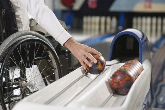 Mid section view of a man with a Spinal Cord Injury playing ten pin bowling