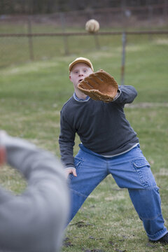 Disabled man playing baseball with his son Disabled man smiling with his son with Down Syndrome