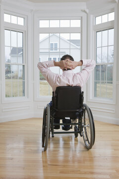 Man Sitting In A Wheelchair With His Hands Behind His Head