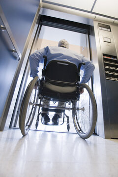 University professor with Muscular Dystrophy in a wheelchair entering an elevator