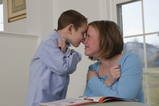 Woman signing the word 'love' in American Sign Language while communicating with her son