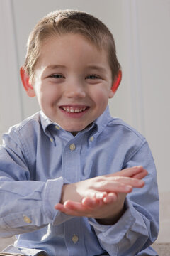 Boy signing the word 'School' in American Sign Language