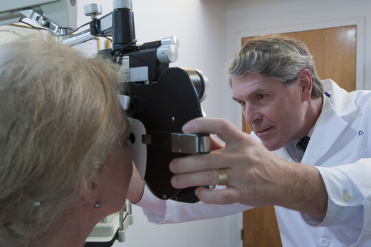 Ophthalmologist examining a woman's eyes with a phoropter
