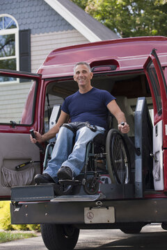 Man with spinal cord injury in a wheelchair getting in his accessible van