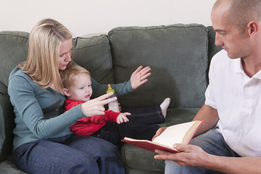 Woman signing the word 'Read' in American Sign Language while teaching her son