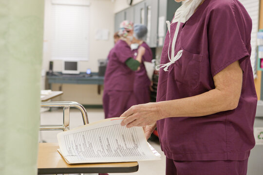 Female nurse examining a medical report after surgery